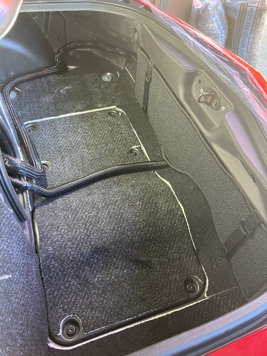 Factory-style trunk trim covering and concealing the custom data-logging installation